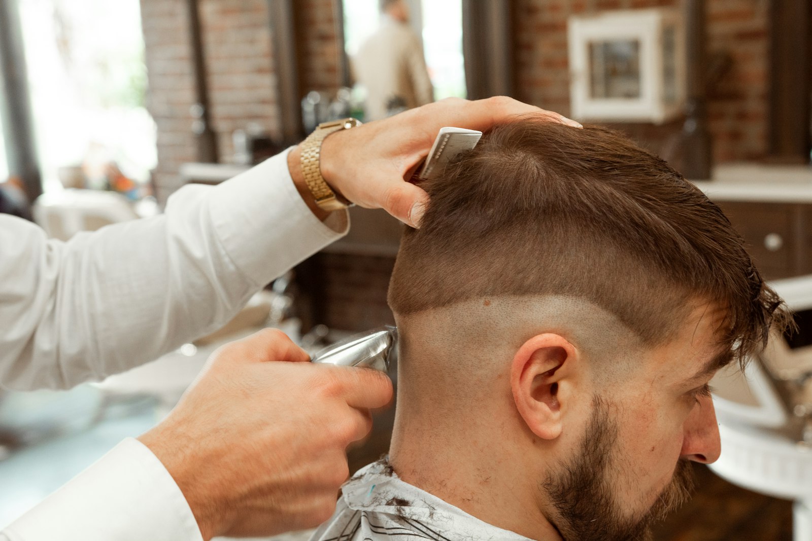 A barber cutting a client's hair in a barber shop