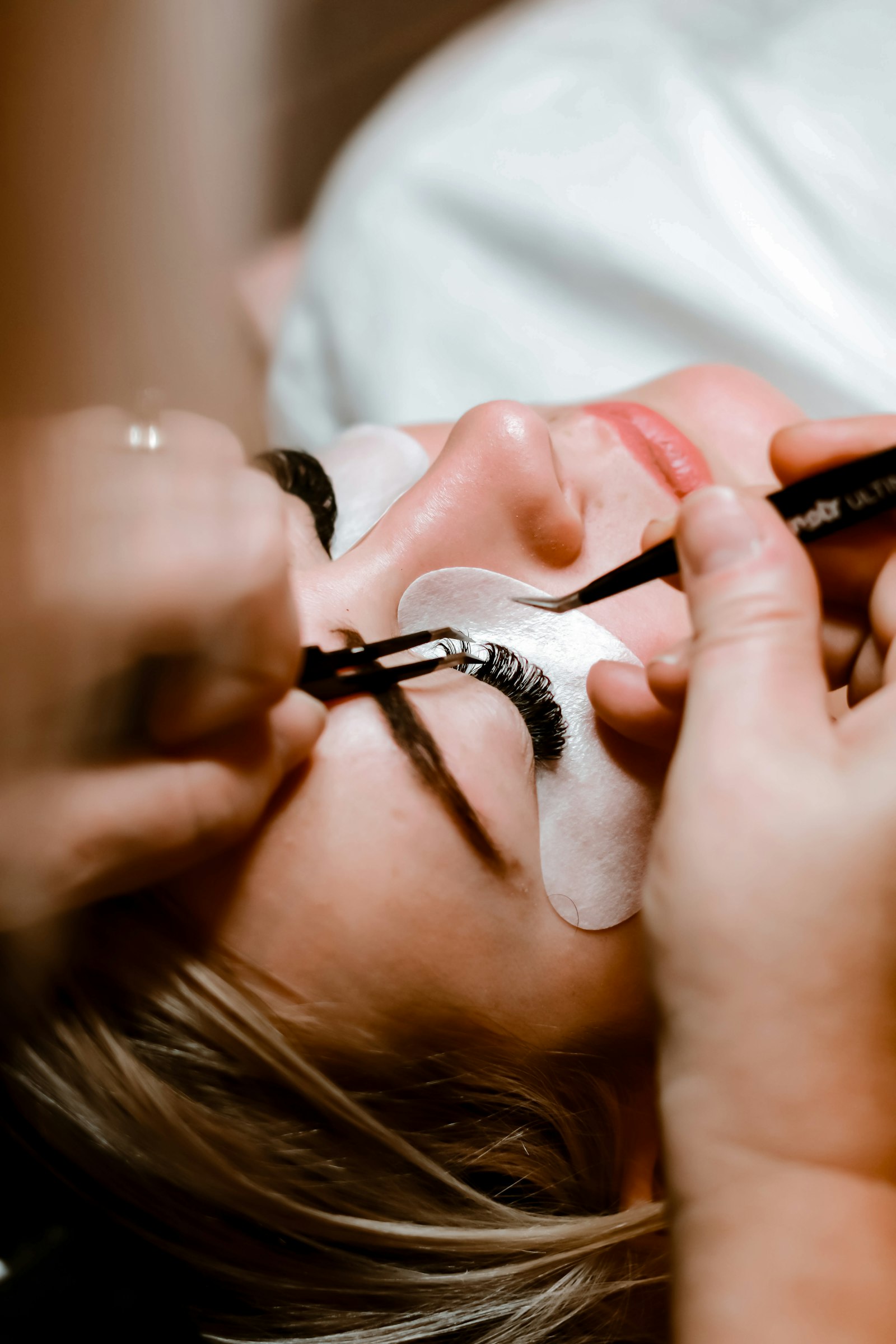 A lash artist applying eyelash extensions to a client