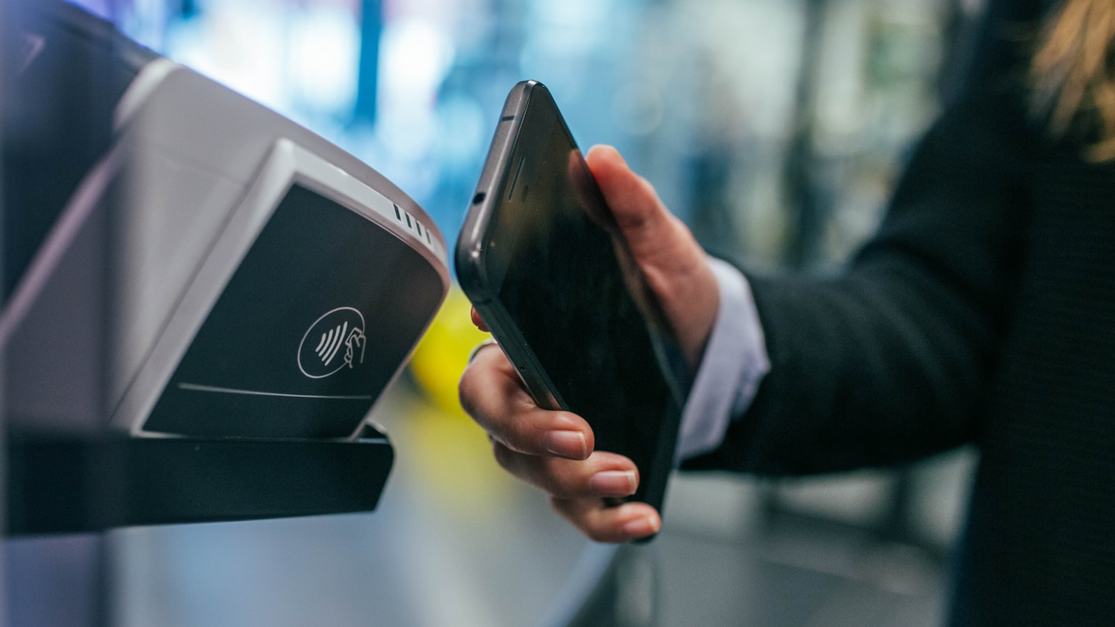 A customer paying by phone at a card terminal