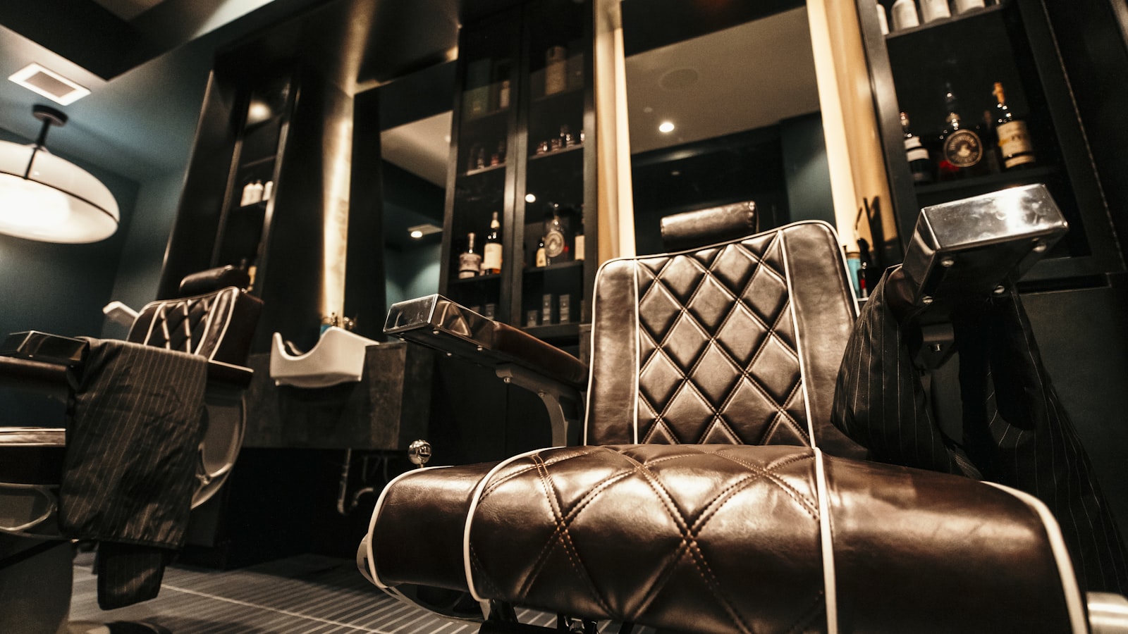 An empty leather barber chair in a dark barbershop