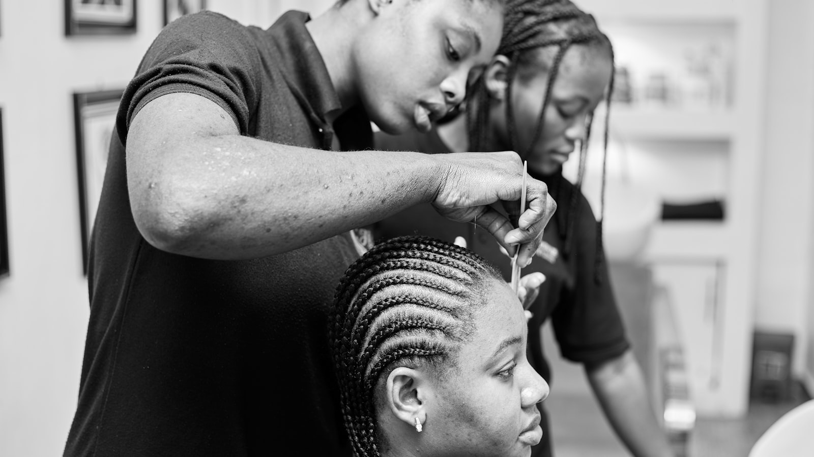A stylist working on a client's braids in a salon