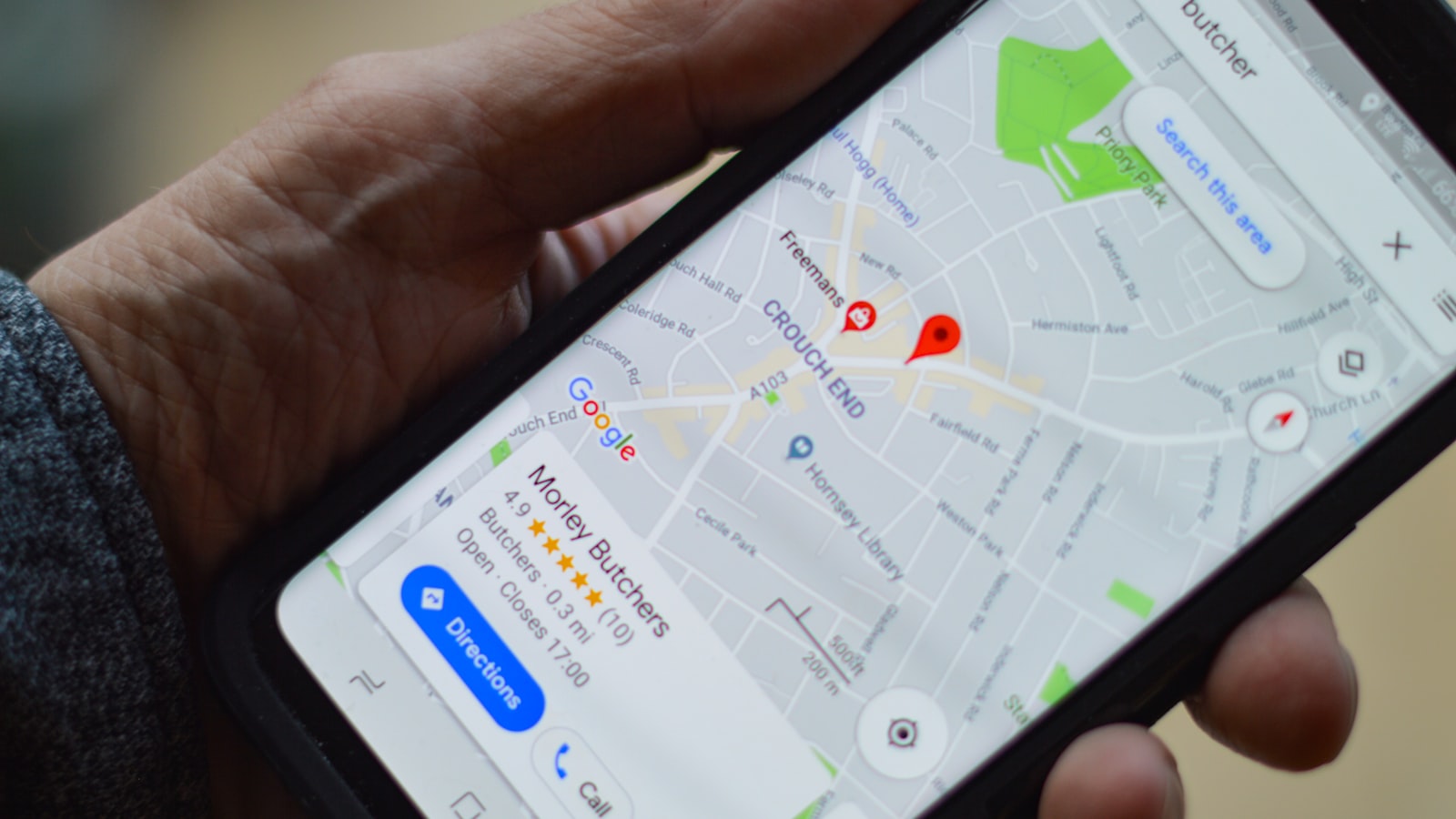 A hand holding a phone showing a local map with nearby places