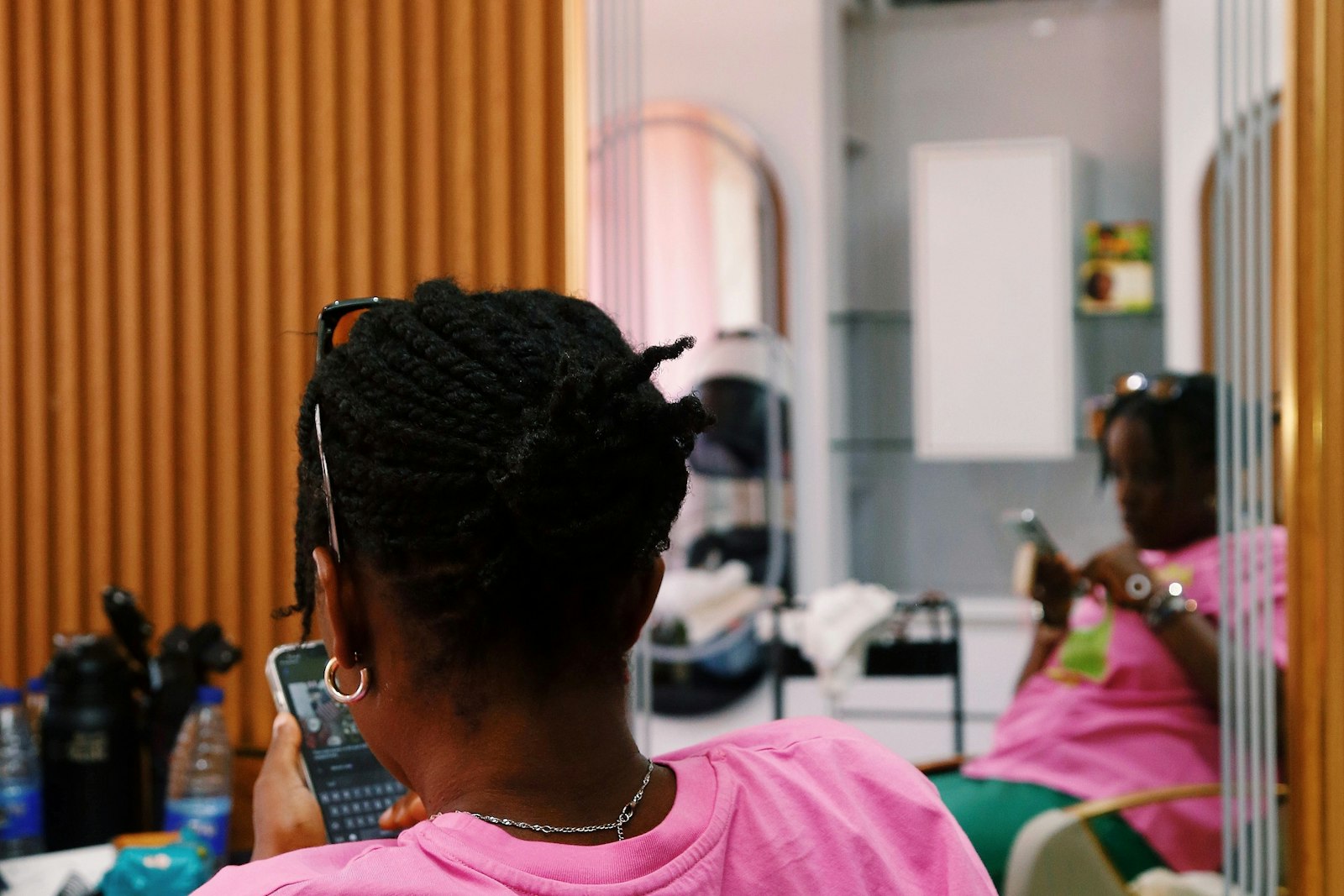 A woman in a salon chair checking her phone