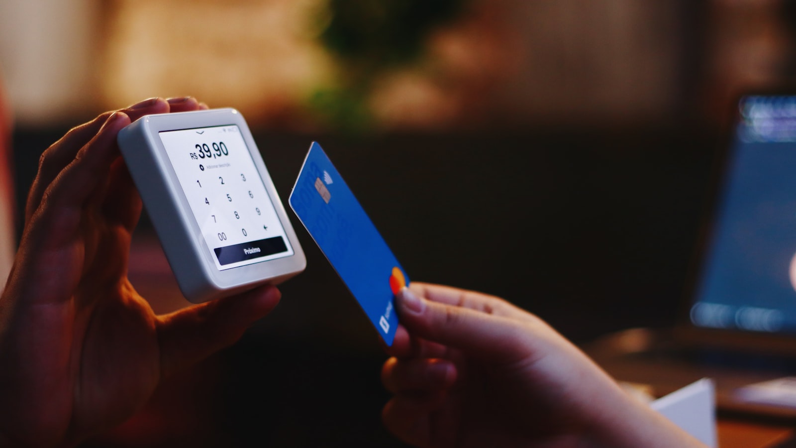 A person holding a credit card and a phone