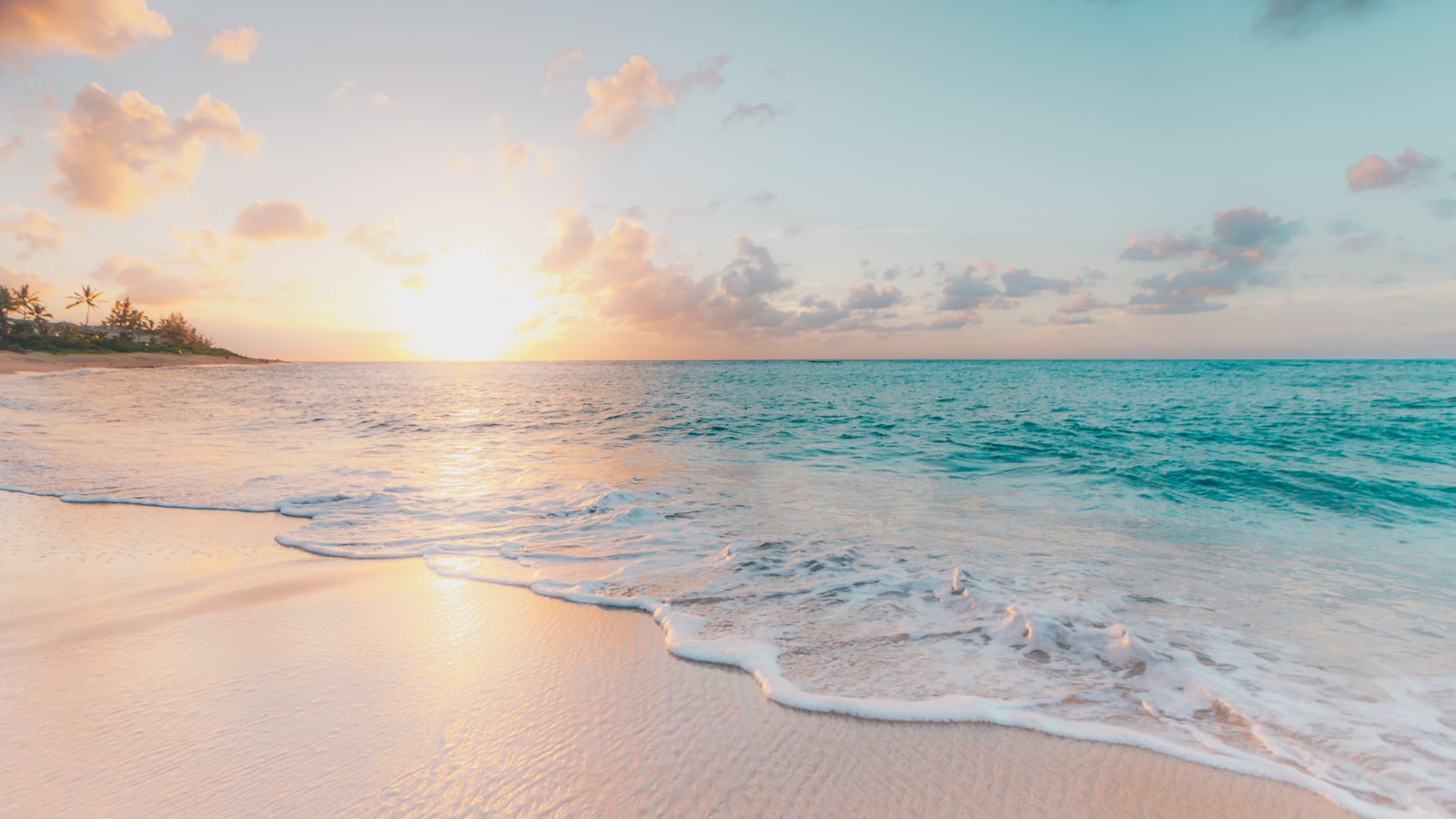 Une plage calme au coucher du soleil, une vague léchant le sable