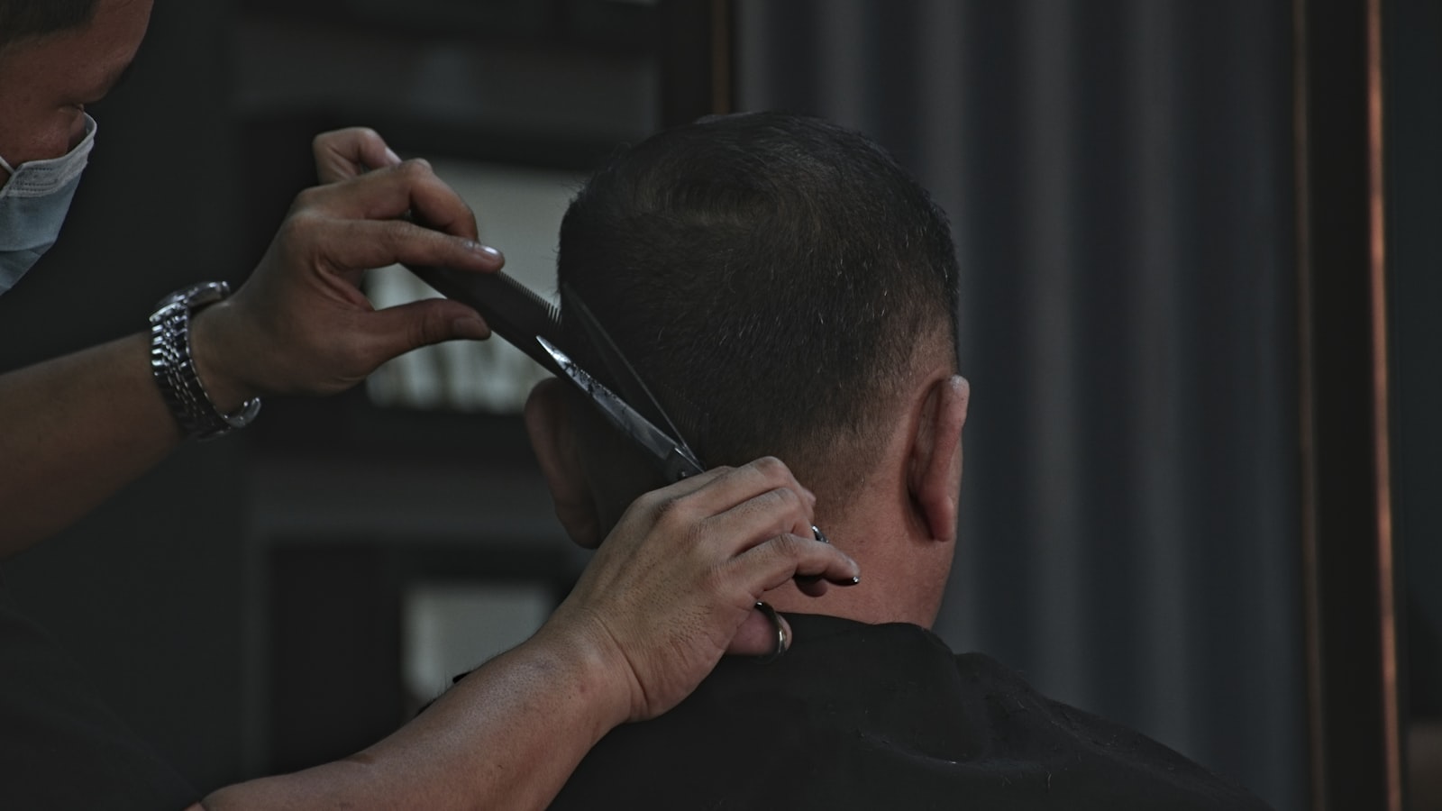 A barber trimming a client's hair